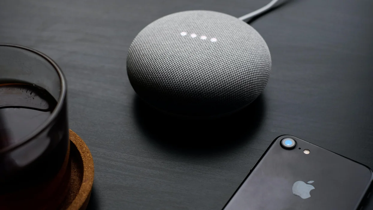 Google Home Mini with an iPhone on a table surface
